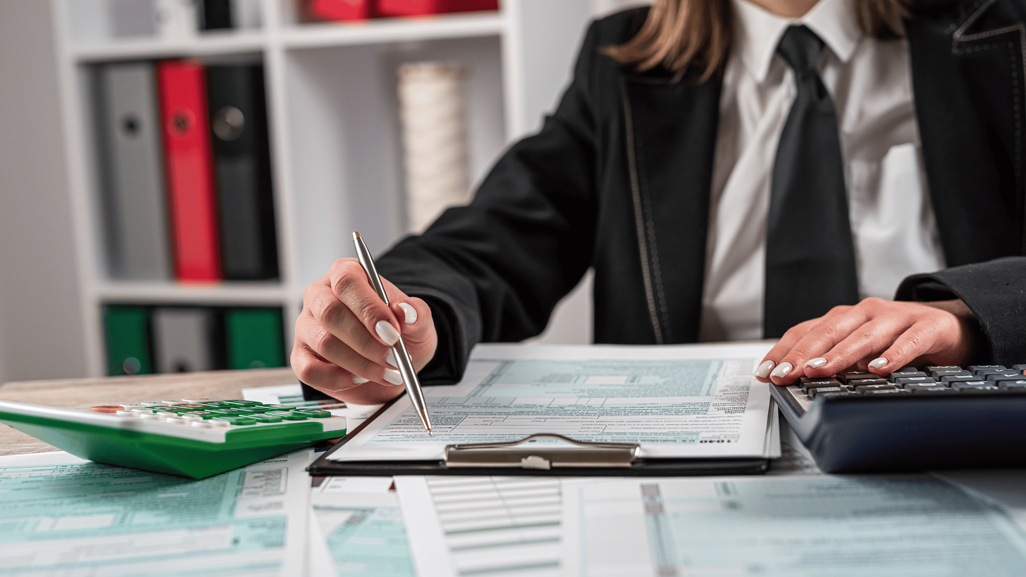 Profissional realizando análise de documentos fiscais e utilizando calculadora para emissão de certidões negativas e positivas com efeito de negativas, garantindo conformidade jurídica e regularidade fiscal.